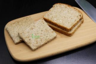 用面包刀切去吐司的四周的边，边角比较硬，不想浪费的，可以切完再吃也很美味。