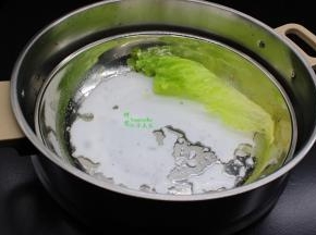 不锈钢的平底盘涂抹一层油。倒入一勺米浆在蒸盘上，左右摆动一下，让米浆在薄薄一层在蒸盘上，放入生菜。