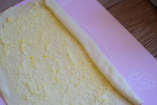 把面团分成两份，每一份都擀成长方形，把椰蓉铺在面片上面，从一头卷起来，