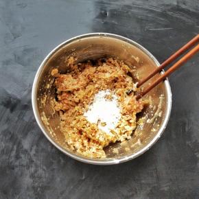 再加入捏干水分的萝卜丝和豆腐，拌匀，最后再加入玉米淀粉增加它的粘性，拌匀