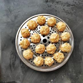 在手上抹少许香油，一转一楼将肉馅挤成小球，下入锅中隔水蒸五分钟，让它定型，油有滑嫩的作用，让丸子表面光滑不粘手