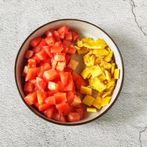 再把煎好的蛋黄切成小丁，西红柿也切成同样大小的小丁。