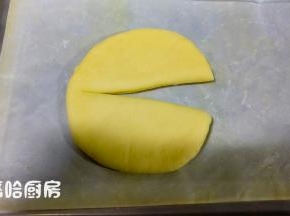 醒发后的面团，先从重量最大的开始整形。面团按压拍扁，擀开成圆形，用刮板在面团上压出6等分的痕迹，用刮板在面团的中间切开，但不要切断，把切口展开。