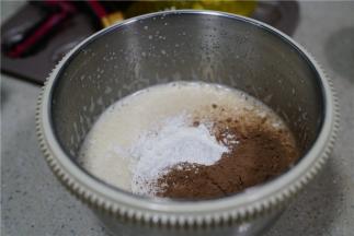 然后将可可粉，糕点专用粉，泡打粉混合加至到蛋液里，拌至无干粉状。