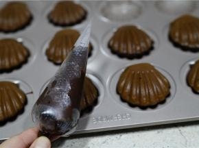 将巧克力高温溶好，然后挤在玛德琳表面，再用巧克力豆点缀一下就可以。