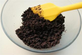 奥利奥饼干去掉夹心，压碎，加入融化的黄油混合均匀。4寸学厨KT慕斯模具放置在盘子里，下面包上锡纸，把黄油饼干碎压紧在底部，放入冰箱冷藏半小时使凝固。