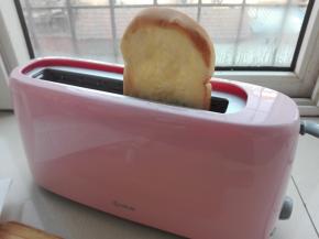 将压好花纹的吐司片放入多士炉中。