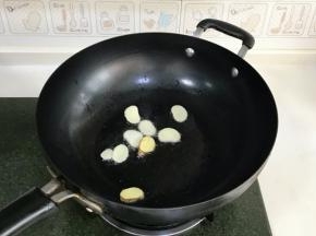 开火，往锅中倒入适量的食用油，接着入蒜片和姜片爆香。