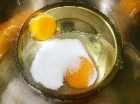 盆里打入鸡蛋加入细砂糖搅拌至砂糖融化