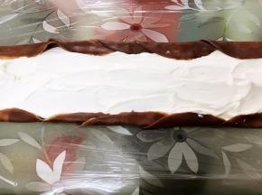 底部铺上保鲜膜，叠着摆放5到6张面皮，中间抹上淡奶油，两边不抹叠起