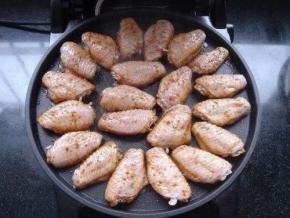 电饼铛上下盘预热，下盘刷少许油，把腌好的翅中依次放入，在翅中表面刷上一层稀释的红烧汁，合上上盖，开始烤制。2分钟后，锅边出现大量热气，掀开上盖，把鸡翅翻面。