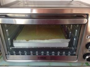 拌好的蛋糕糊倒入铺了油纸的烤盘里，在桌面上震出气泡，放入到已提前预热到180度的烤箱下层，烘烤18分钟左右，实际烘烤温度要根据自家烤箱脾气而定