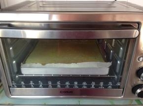 拌好的蛋糕糊倒入铺了油纸的烤盘里，在桌面上震出气泡，放入到已提前预热到180度的烤箱下层，烘烤18分钟左右，实际烘烤温度要根据自家烤箱脾气而定