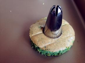 烘烤好的蛋糕取出，晾凉3分钟，再倒扣到烤架上，趁热撕去油纸。待放凉后，用圆形模具按压出12块蛋糕片，用花型的模具压出3块蛋糕片。其中9块的圆形蛋糕片，用大号的裱花嘴在中间压出圆形，你也可以用其他模具压出