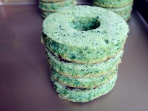 底部放完整的圆形蛋糕片，依次放上3片中间压了小圆形的蛋糕片，每一片之间都抹上融化了的巧克力固定着