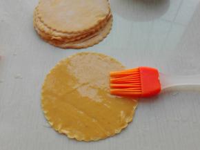 因为我用的压面机直接压的一个大薄片，所以用圆形模具再分别扣压出了小的圆形面片，分别在上面刷上一层食用油，如果用擀面杖的话，将发酵好的面团等分成十个面团，其中九个面团一样大，一个面团要稍微大一点，然后用擀面杖将其全部擀成圆形薄片