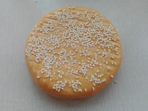 反过面来，在顶面上抹点水，然后撒上芝麻，稍做按压