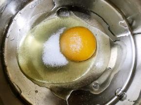 盆里打入一个鸡蛋，加入细砂糖