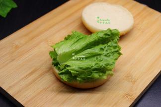 汉堡胚拿开第一层，挤上沙拉，然后放生菜，