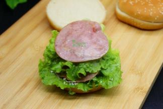 再放一片生菜，沙拉，火腿片，双层火腿就放好。最好盖上汉堡胚，美味的早餐就可以享用了。