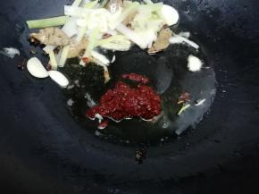 然后再把辣味豆瓣酱放入锅中，炒出红油