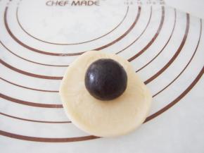 将面团擀开成为圆形，放上枣泥馅包起来。将所有的面团包好，收口朝下放置。