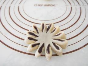 擀成圆形小饼，用刀子切成12份。沿着一个方向卷起来花型。