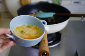 然后将肉末划至一边，将鸡蛋打散下锅炒至凝固。