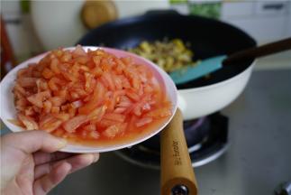 再将番茄去皮切小丁，下锅后拌炒至番茄成沙。