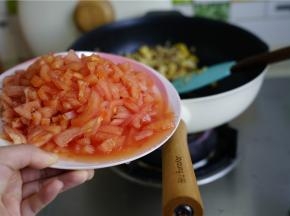 再将番茄去皮切小丁，下锅后拌炒至番茄成沙。