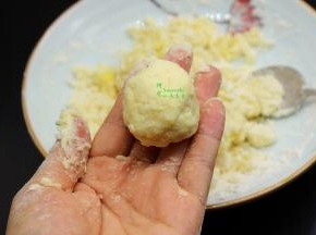 用勺子挖一小勺，揉搓成小团，放在手掌心，按压成圆圆的小饼