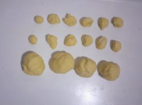 把玉米面团分别成2个1~2克的小小面团(制作耳朵)，10个5~6克的小面团(制作腿和尾巴)，2个35克的中面团(制作头部)，把剩余的分成2份大面团(制作身体部分)