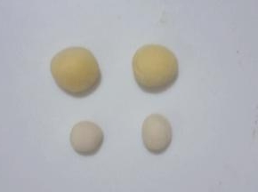 在取两个豌豆粒大小的白面团，与刚才分出的玉米面小小面团分别搓圆