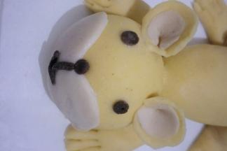 三个搓圆，分别粘少量清水贴在老虎的眼睛处鼻子处。另外两个搓长条制作出老虎的嘴巴，粘少量清水贴在相应位置如图