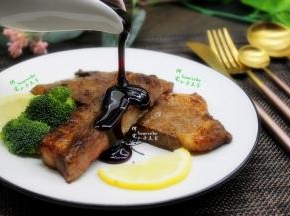 煎好的牛排切成二块，装入盘子，加点装饰食材柠檬片，在牛排上挤几滴柠檬汁，然后把熬煮好的红酒调料汁，淋在牛排上，