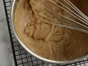 五次以后，面糊开始变的浓稠，顺滑。每一次静置都会比上次浓稠，顺滑。直至图示状态即可。这就完成了鸡蛋，糖，黄油的乳化。面团香气十足。然后倒入一个稍大的容器里。