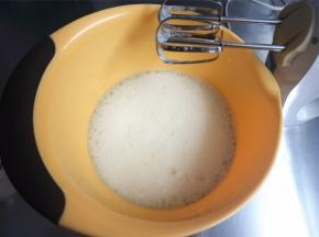 先用低速搅打至鱼眼泡状态，加入第一次细砂糖（16克细砂糖分3次加入，每次5克左右）。