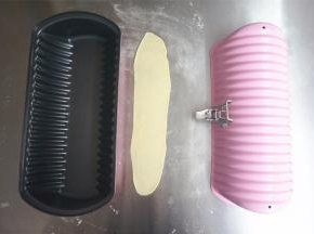 取一个15克的白面团，擀开成长条，长度比模具略短一些即可，放置在模具中央。