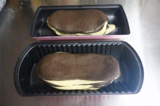 把一个20克的黑色面团，25克的白色面团，25克的黑色面团，35克的白色面团，35克的黑色面团分别擀成长度厚度一致的面片，随着重量的增加，面片宽度也会增加。由小到大依次叠放进去。剩下的面团分别擀开，这次按照大到小的顺序依次叠放。重叠面皮时，左右侧稍微错开，图案更漂亮。