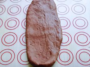 取一块面团，用擀面杖擀开，将气泡拍破。