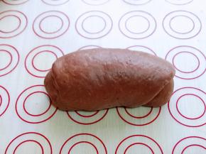 将擀好的长舌状两边向中间对折，用擀面杖轻轻擀长，由上而下卷起。

