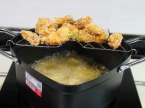 炸好的鸡肉放入炸锅架上，多油的油漏干，继续炸第二锅，把鸡块全部炸完。