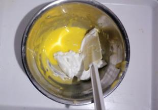 取三分之一蛋白放入蛋黄糊中用刮刀翻拌均匀，不可画圈搅拌