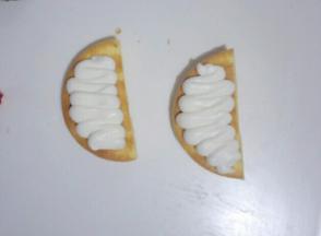 把打发好的淡奶油装入裱花袋挤在蛋糕底部，如图