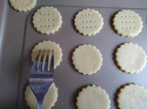 将饼干胚移至不粘烤盘上，用叉子戳出一个个小孔，可以防止饼干在烘烤中变形