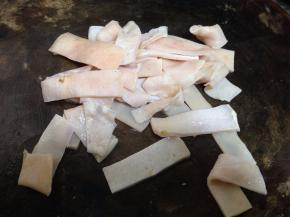 猪皮刮去表皮猪毛和猪皮上油脂然后洗净，切成两指宽的条