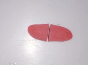 小红色面团搓长按扁，从中间一分为二，把尖端捏起，制作小猪的耳朵