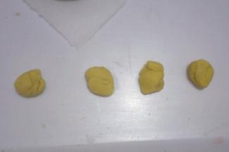 把黄色面团分出4等份，分别搓成长条，做出2、0、1、9四个数字。