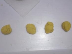 把黄色面团分出4等份，分别搓成长条，做出2、0、1、9四个数字。