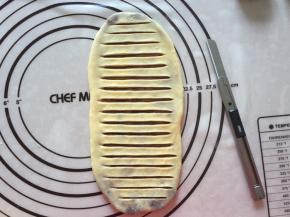 封口朝下，擀成牛蛇状，用锋利的刀划出口，不要划到底